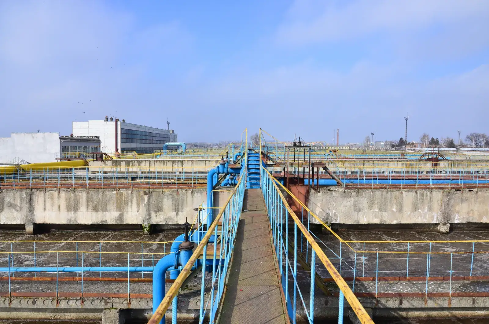 Settling tanks and blue pipework at a water treatment plant