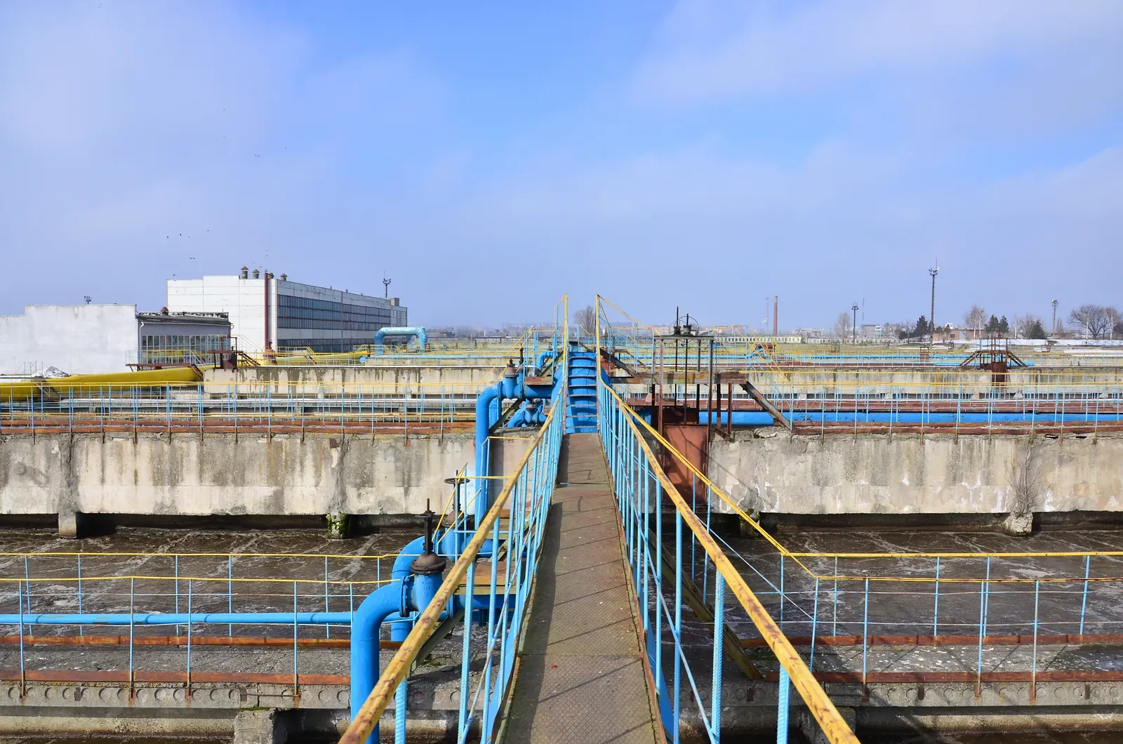 Settling tanks and blue pipework at a water treatment plant